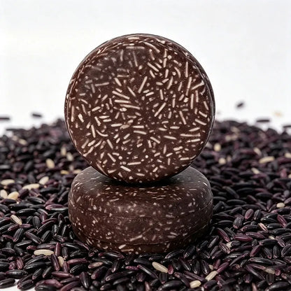 Two round Black Glutinous Rice Shampoo Bars displayed on black rice